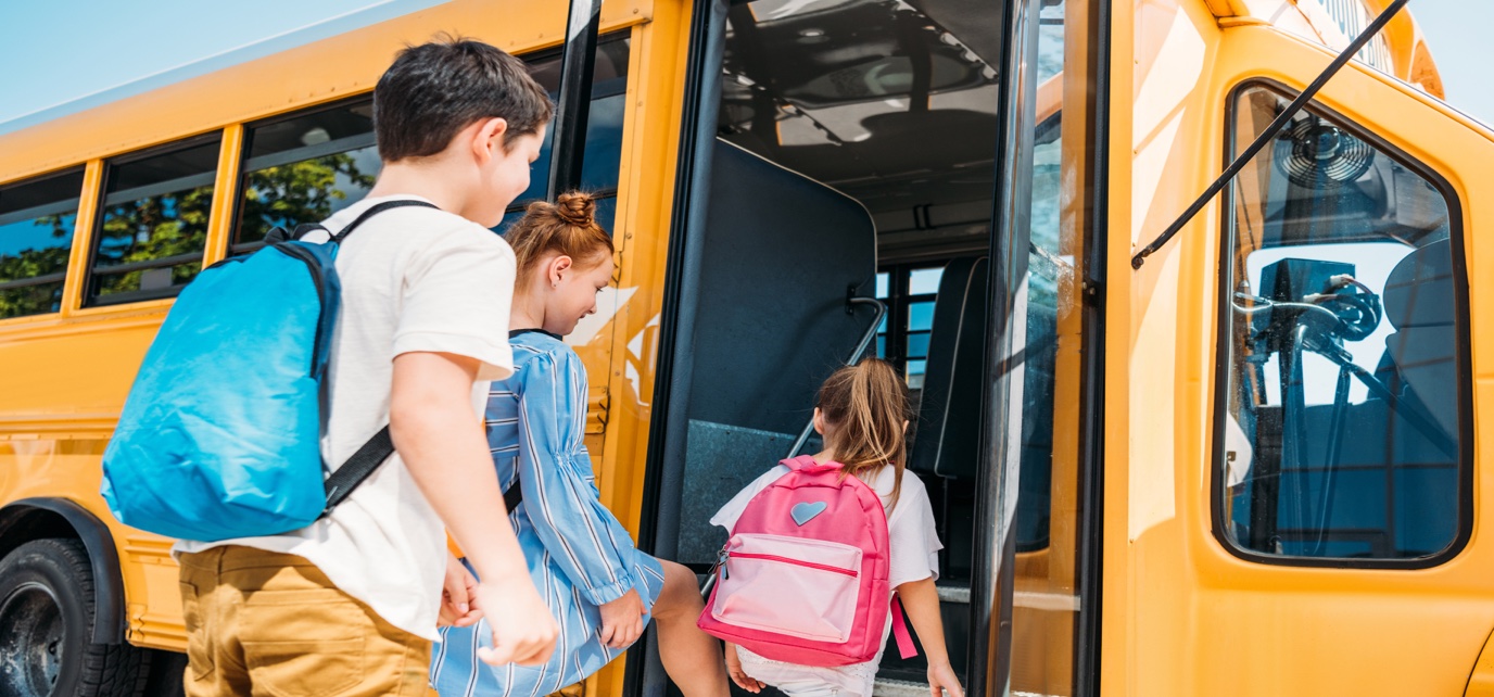 Estudiantes subiendo a un autobús escolar americano amarillo